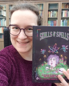 Photo of Minerva holding up Skulls & Spells