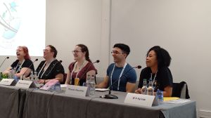 Photo of the 5 panellists at a table with microphones.