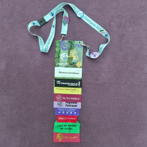 Photo of a convention badge attached to a lanyard and with 8 ribbons.
